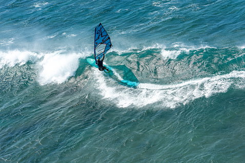 Fanatic Mamba TE Windsurf Waveboard beim Wellenreiten im Ozean in cyan und türkis