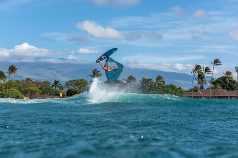 Fanatic FreeWave Windsurf Wellenboard beim Wave-Riding mit Aerial-Manöver in tropischer Küstenumgebung
