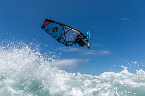 Fanatic FreeWave TE windsurf board during wave riding with aerial jump over the ocean