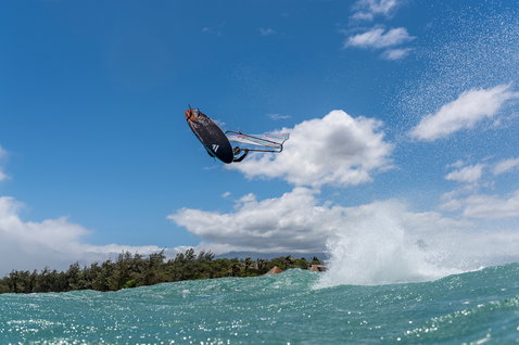 Fanatic FreeWave TeXtreme wave windsurf board during wave riding with aerial jump over the ocean