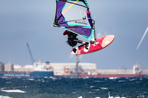 Fanatic Grip XS wave windsurf board during wave riding on the ocean in coral and dark blue