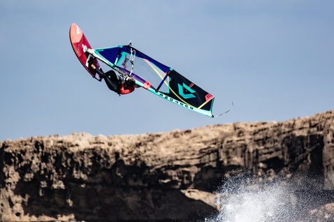 Fanatic Grip XS wave windsurf board during wave riding at rocky coastal cliffs