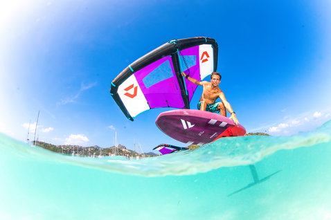 Fanatic Sky Wing foil board during wing foiling in a tropical bay in violet and magenta