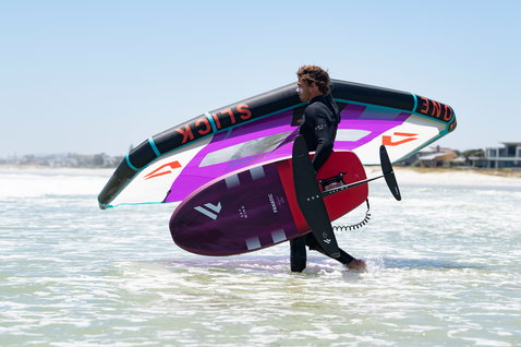 Fanatic Sky Wing foil board during wing foiling at the beach in purple and red with foil assembly