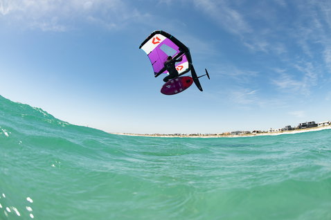 Fanatic Sky Wing foil board during wing foiling above turquoise ocean with purple Duotone wing