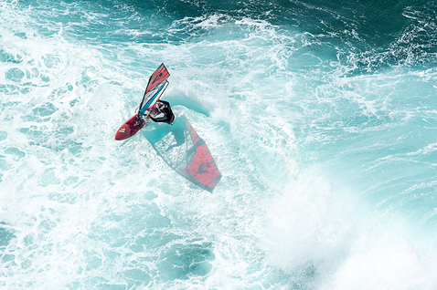 Fanatic Grip TE wave windsurf board during wave riding on the ocean aerial view