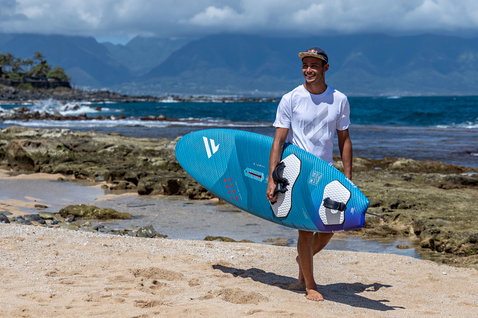 Fanatic FreeWave TE windsurf board in teal during wave riding at a tropical beach