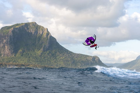 Fanatic Duotone Carbon TE mast & fuselage set during wing foiling above the ocean with mountain backdrop