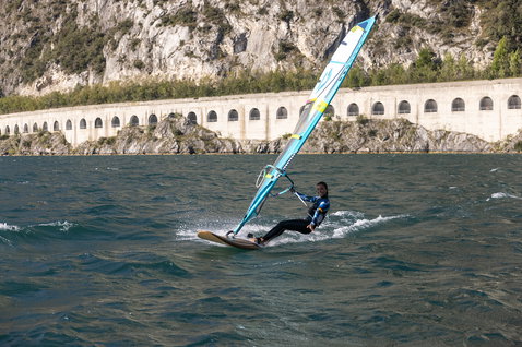 Fanatic Gecko Eco freeride windsurf board during windsurfing on Lake Garda with rocky backdrop