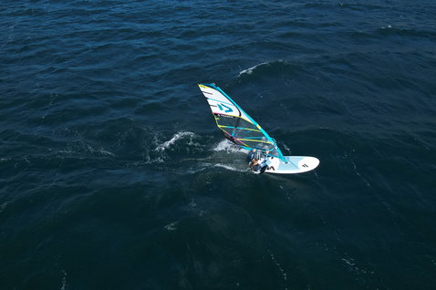Fanatic Gecko HRS freeride windsurf board during windsurfing on open ocean aerial view