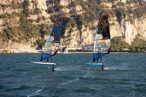 Fanatic Stingray LTD windsurf foil board during wind foiling on a lake with rocky cliffs