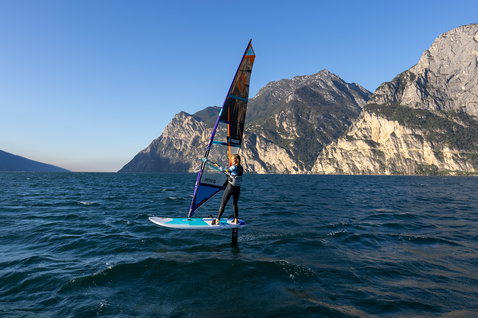 Fanatic Stingray HRS windsurf foil board during wind foiling on an alpine lake with mountain backdrop