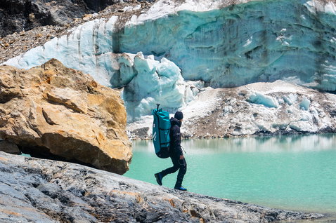 Duotone Fly Air Pocket iSUP Rucksack beim Trekking an einem Gletschersee in den Bergen