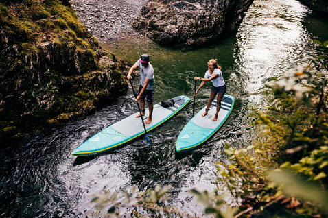 Duotone Ray Air Premium aufblasbares Touring-SUP-Board beim Paddeln in einer felsigen Flussschlucht
