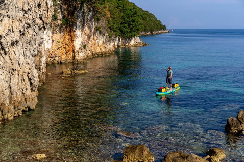 Duotone Ray Air Premium aufblasbares Touring SUP Board beim SUP-Touring in einer Felsbucht am Meer