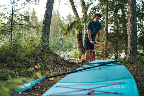 Duotone Ray Air inflatable touring SUP being prepared at a forest lakeside in Finland