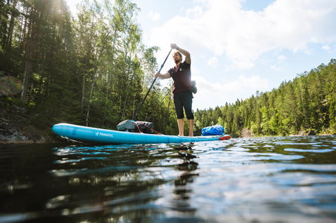 Duotone Ray Air inflatable touring SUP board during paddling on a forest lake in Finland