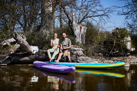 Duotone SUP Ray Air Pocket iSUP 11'6" in lila und türkis-gelb beim Paddeln am Fluss im Frühling