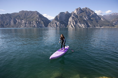 Duotone Diamond Air Touring Pocket inflatable SUP touring board in purple during stand up paddling on an alpine lake