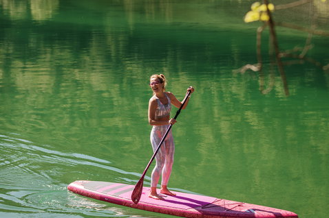 Fanatic Diamond Air Touring inflatable SUP board 11'6" in coral during stand-up paddling on an alpine lake