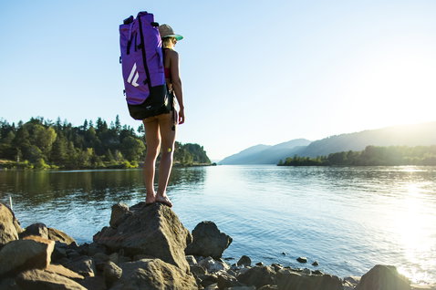 Duotone Diamond Air Touring Pocket inflatable SUP bag in purple during SUP touring by the river