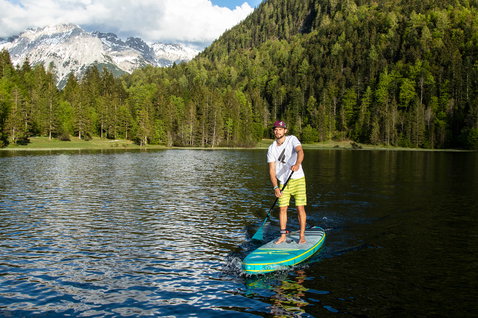 Duotone Ray Air Premium aufblasbares Touring SUP-Board beim Paddeln auf einem Bergsee