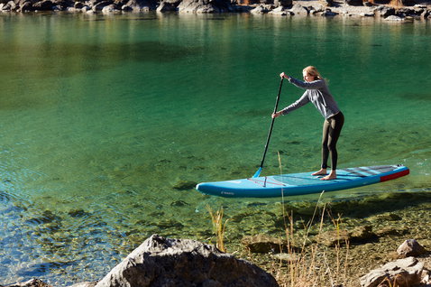 Fanatic Ray Air Pure inflatable touring SUP board during stand up paddling on a clear alpine lake