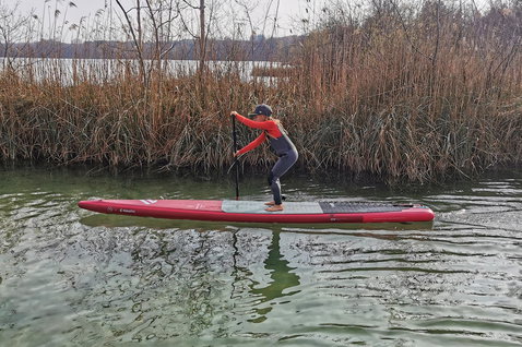 Fanatic Falcon Air Young Blood SUP gonflable de course 12'6" en rouge lors d'une session de paddle sur lac intérieur
