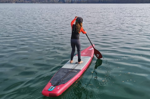 Fanatic Falcon Air Young Blood SUP gonflable de course 12'6" en rouge et blanc lors d'une session de stand up paddle sur lac calme