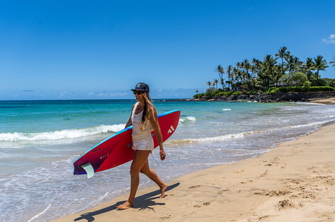 Fanatic FreeWave windsurf board carried on a tropical beach in Maui during wave riding