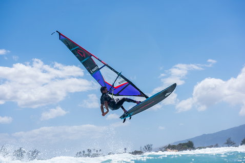 Fanatic FreeWave TeXtreme Windsurf Board beim Wellenreiten mit aerialem Sprung über dem Meer