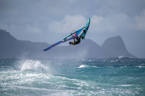 Fanatic Mamba TE Windsurf-Waveboard beim Wellenreiten vor Maui mit vulkanischer Bergkulisse