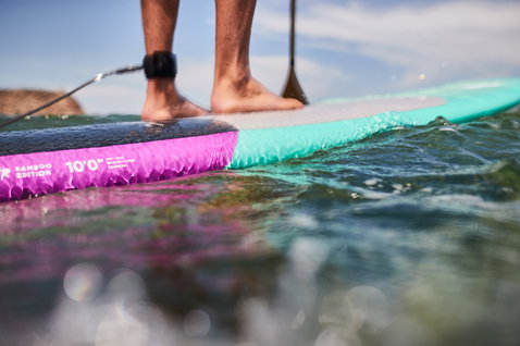 Planche SUP Duotone Stylemaster Bamboo Edition 10'0" en magenta et menthe lors du SUP surf en mer