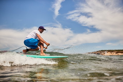 Planche de SUP de vague Duotone SUP Stylemaster Bamboo lors du surf de vague sur l'océan en turquoise