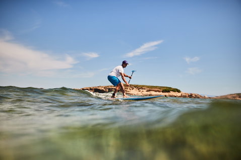 Duotone Stylemaster Bamboo planche SUP de vague lors d'une session de stand-up paddle sur une côte rocheuse