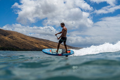 Duotone Sky SUP planche de foil en action lors de SUP foiling sur une vague en côte tropicale à Maui
