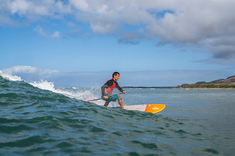 Planche SUP Duotone Bee lors d'une session de SUP surf sur une vague à Maui en orange et blanc