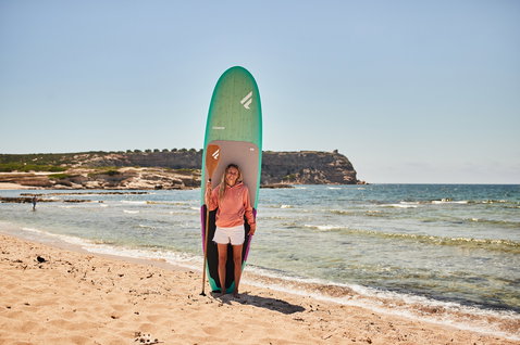 Duotone Bamboo Carbon 50 SUP paddle 7.3" with bamboo carbon blade during stand-up paddleboarding at the beach