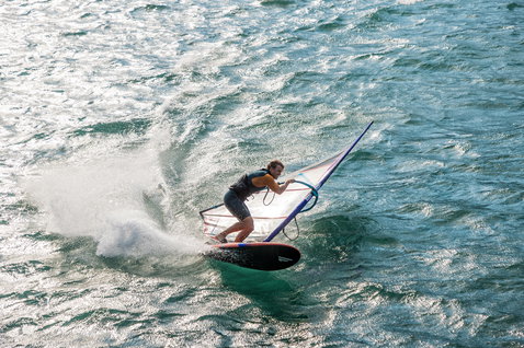 Fanatic Falcon Slalom TE windsurf race board in teal during slalom windsurfing on the ocean