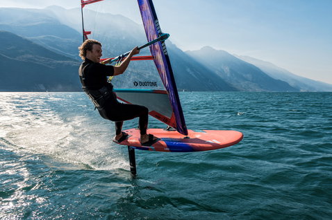 Fanatic Falcon Foil windsurf foil board 180L in red-orange during foiling on an alpine lake