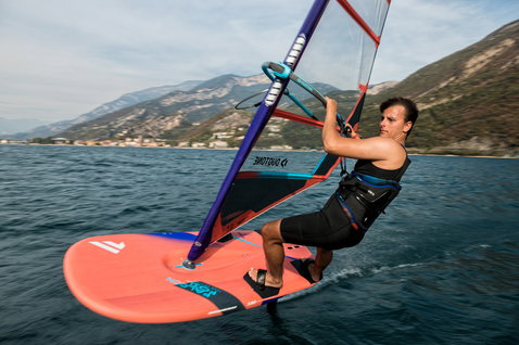 Fanatic Falcon Foil foil windsurf board 180L in coral during foil windsurfing on an alpine lake