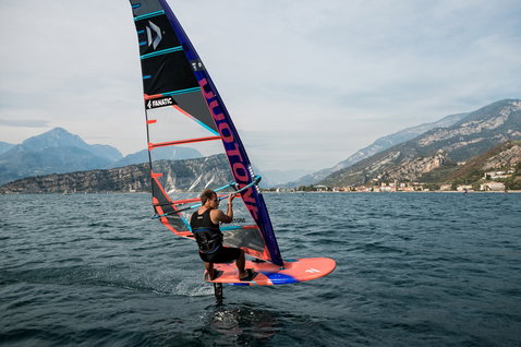 Fanatic Falcon Foil TE windsurf foil board during foiling on an alpine lake with mountain backdrop
