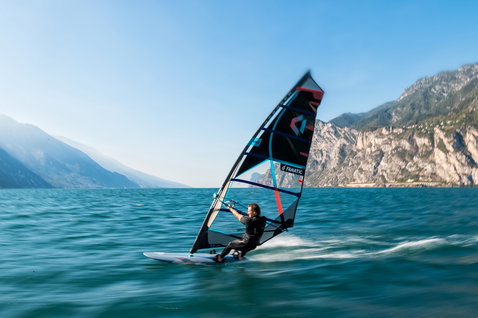 Fanatic Jag LTD windsurf board during windsurfing on an alpine lake with black and teal sail