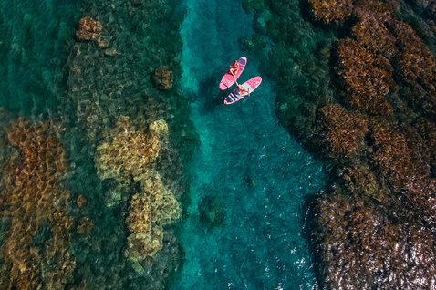 Duotone Diamond Air iSUP Package beim Stand Up Paddling über einem Korallenriff im türkisblauen Meer