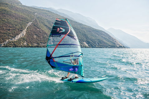 Fanatic Gecko LTD Freeride Windsurfboard beim Windsurfen auf einem Bergsee in türkisblau