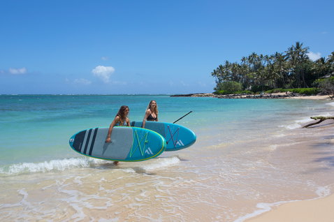 Duotone Fly Air iSUP-Paket in blau und limette beim Stand-up-Paddling am tropischen Strand