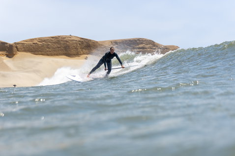 Duotone ProWave LTD SUP surfboard during wave surfing at a sandy beach break