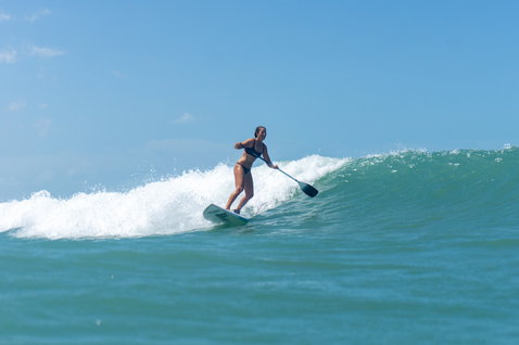 Duotone ProWave LTD SUP surfboard during wave SUP surfing on the ocean on a sunny day