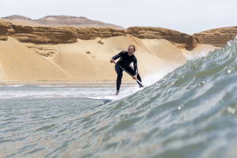 Duotone ProWave LTD planche SUP en train de surfer des vagues sur une côte désertique