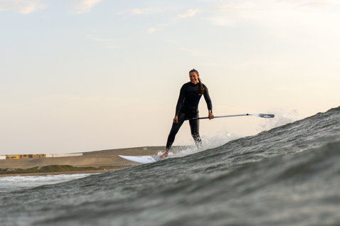 Duotone ProWave LTD SUP surfboard pendant le surf de vague en bord de mer à lumière dorée